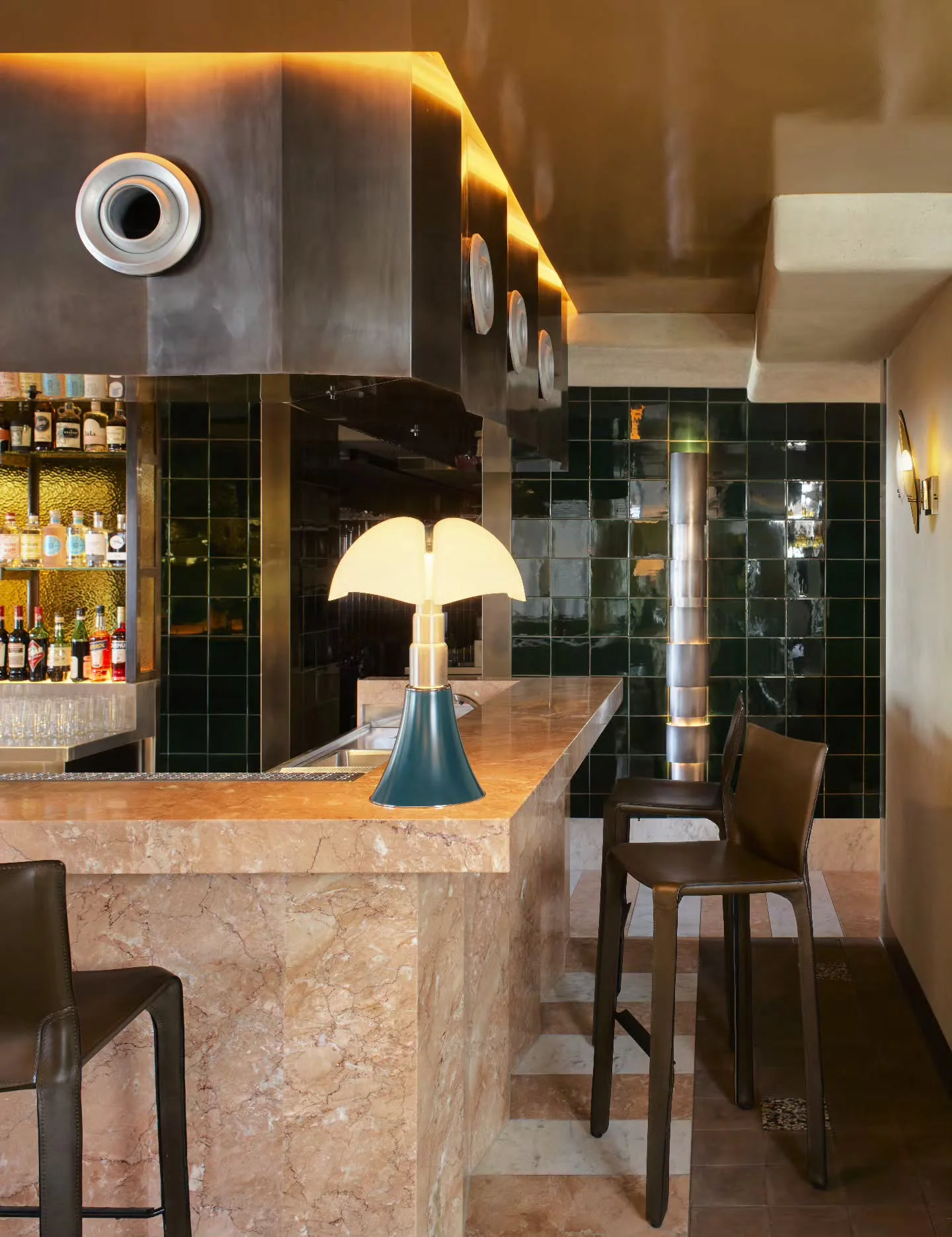 Pink marble bar with green tiles and a mushroom lamp in a restaurant
