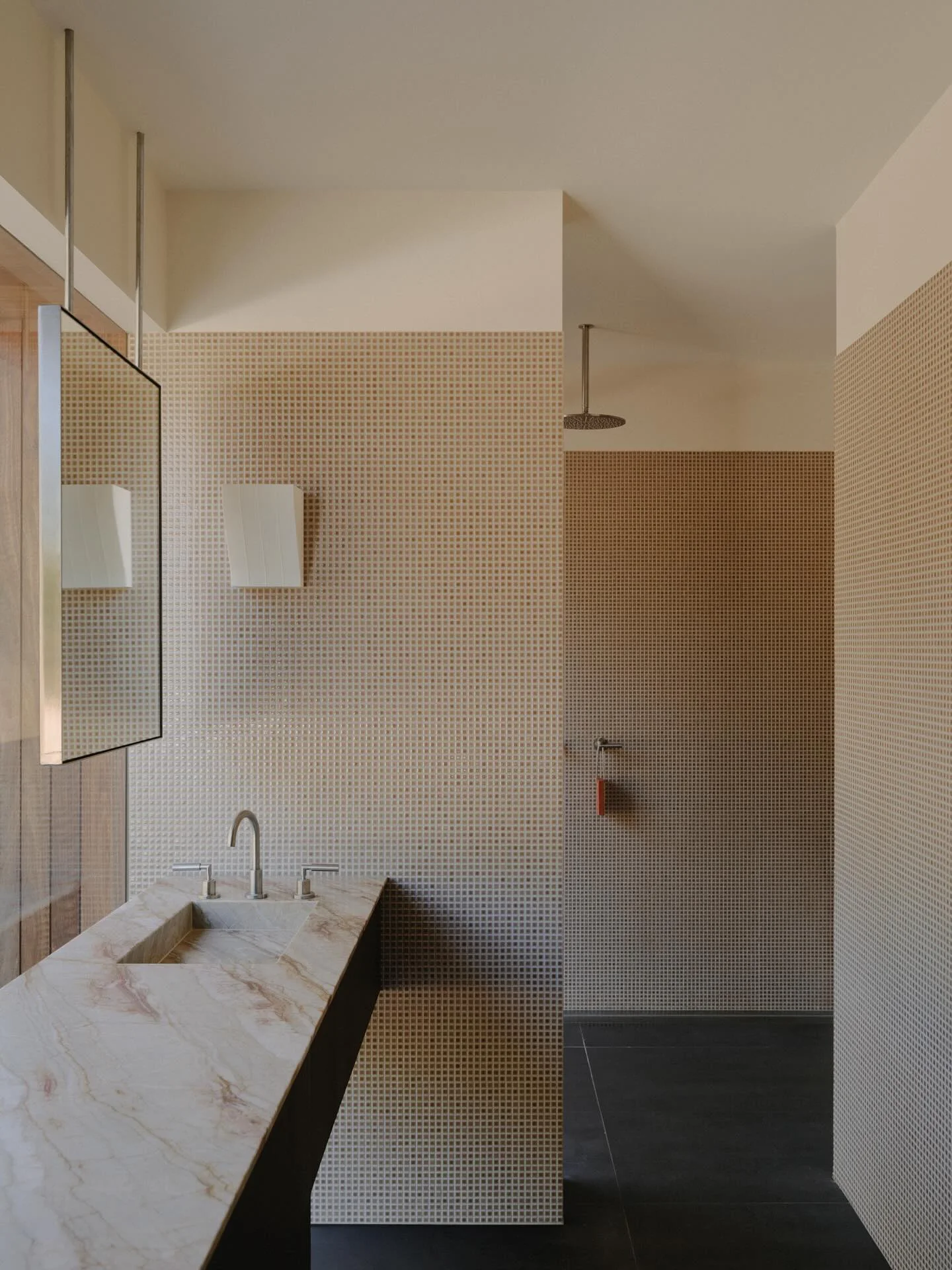 Mosaic tiled shower with a veined stone vanity top