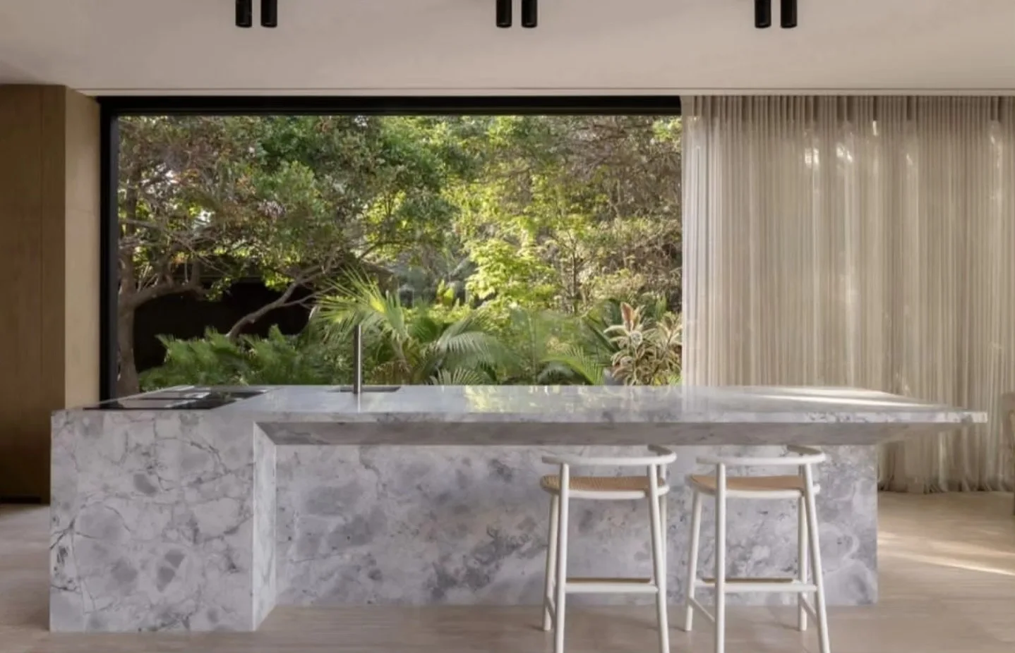 White dolomite island with a waterfall end in front of a garden window